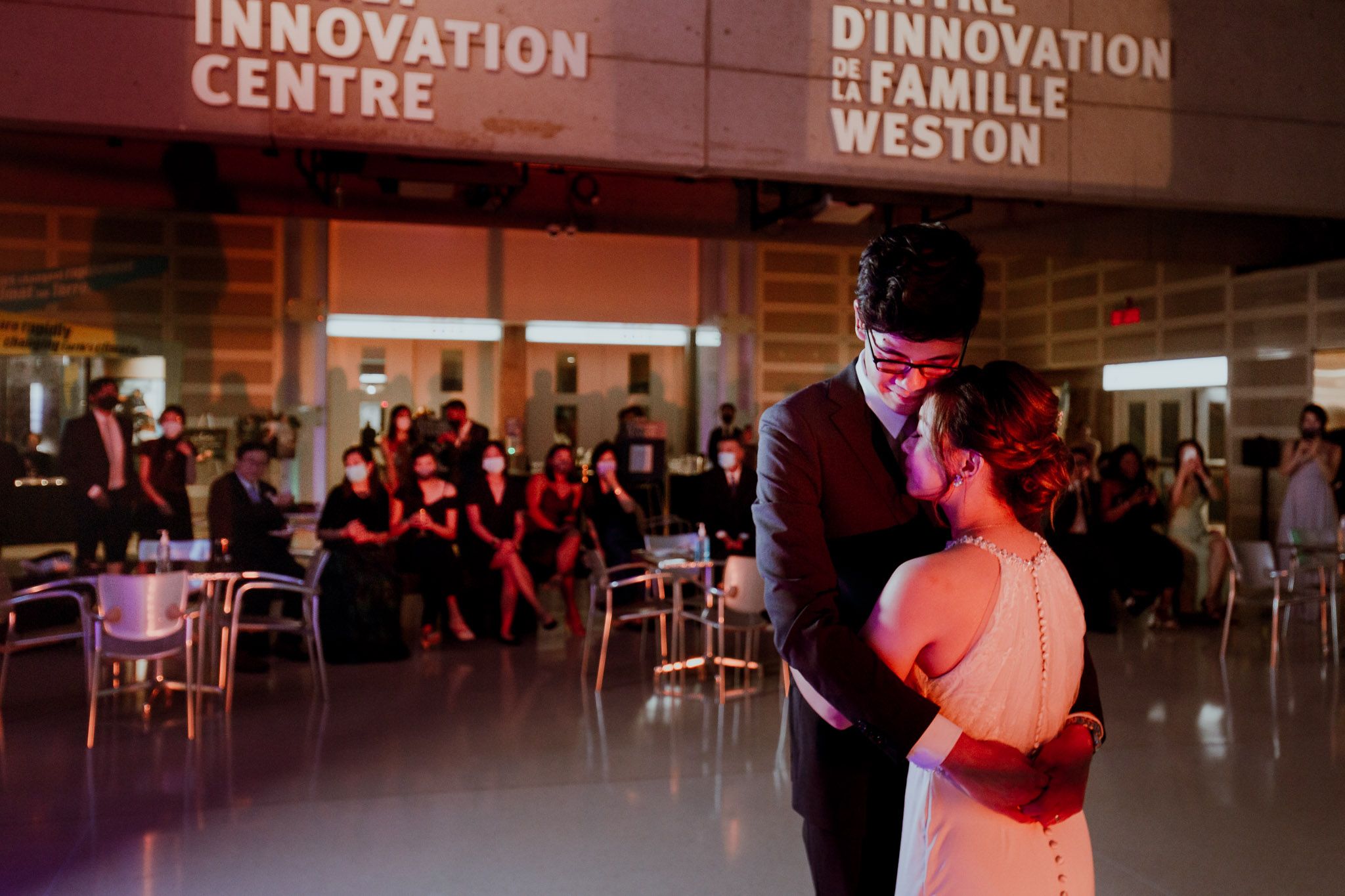 People gather in a modern innovation center space with illuminated signage and seating areas.