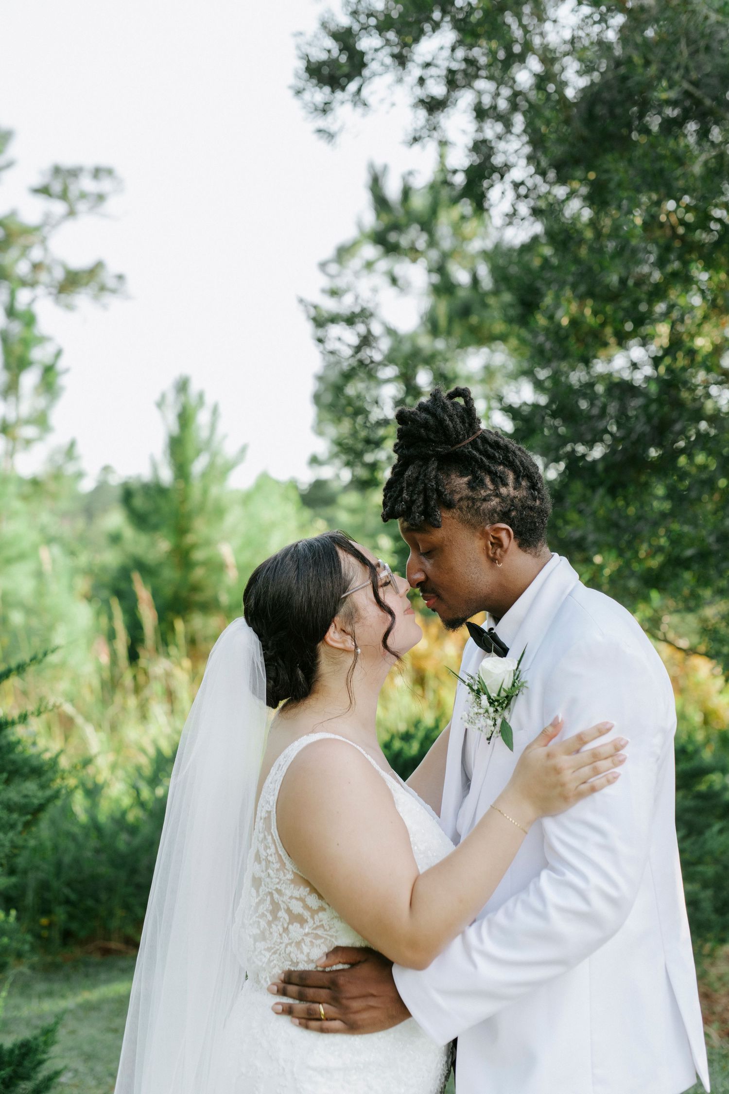 A romantic wedding photoshoot series in a lush outdoor garden setting showing tender moments between the newlyweds.