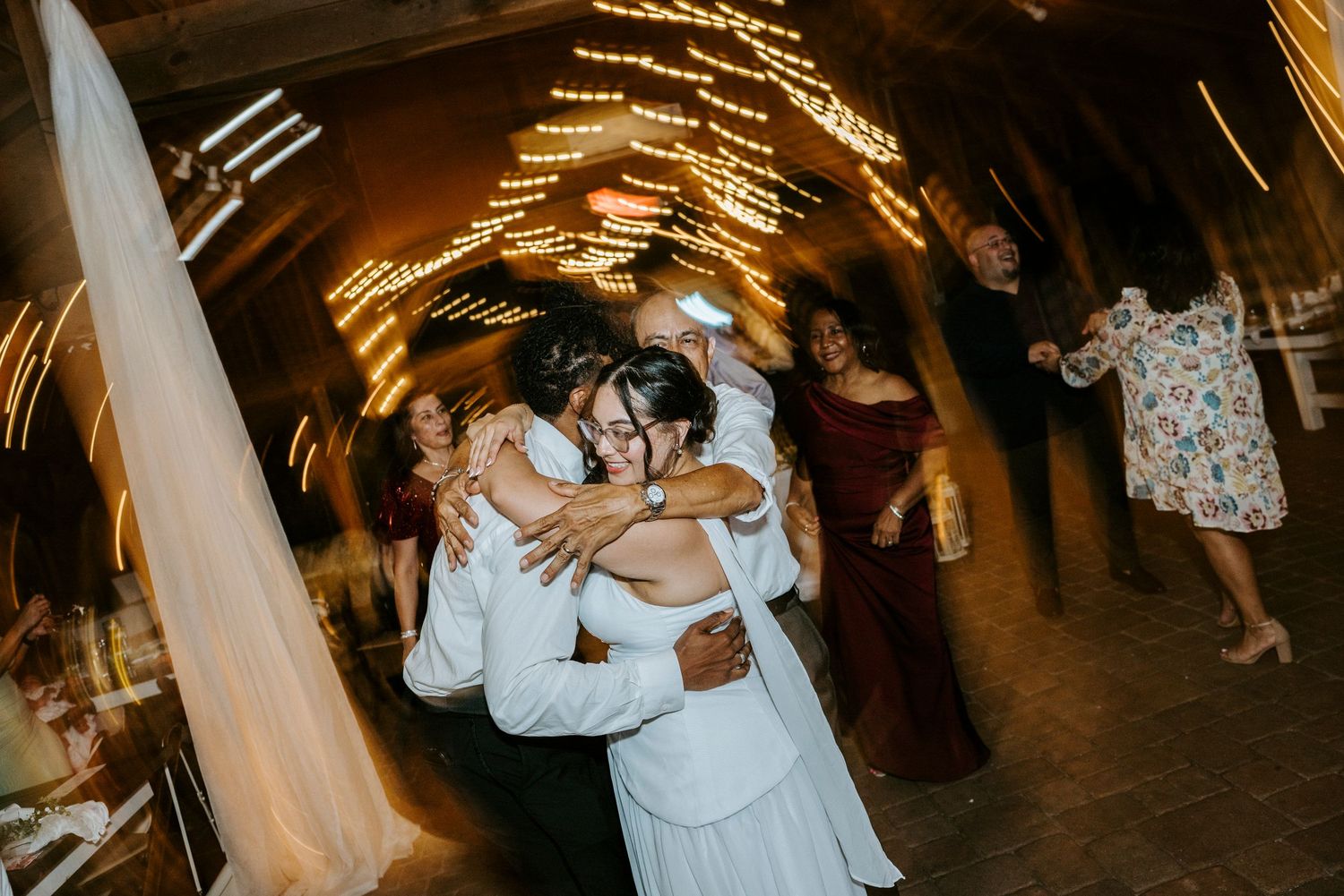 Newlyweds share a romantic dance under twinkling sparkler lights at their evening wedding reception.