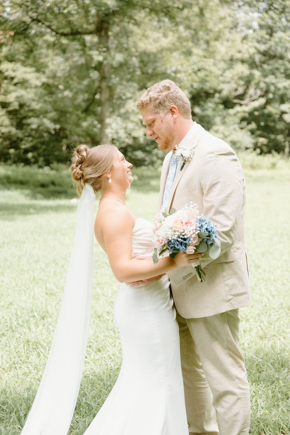 A romantic outdoor wedding moment captured in a sunlit garden setting.