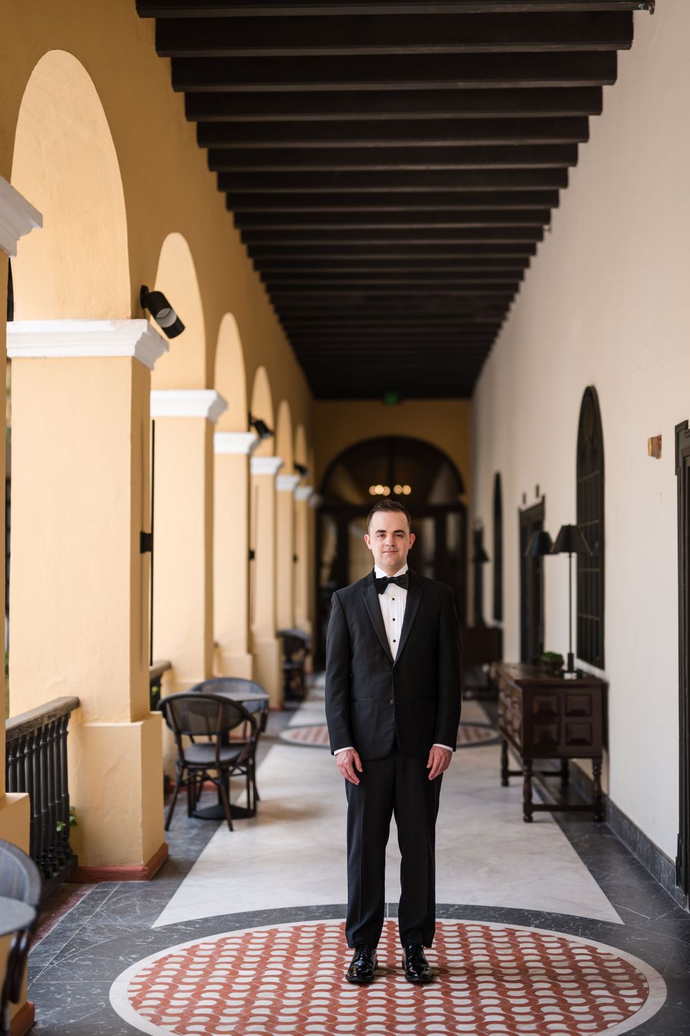 Groom standing in corridor at Hotel El Convento in Old San Juan Puerto Rico before wedding ceremony