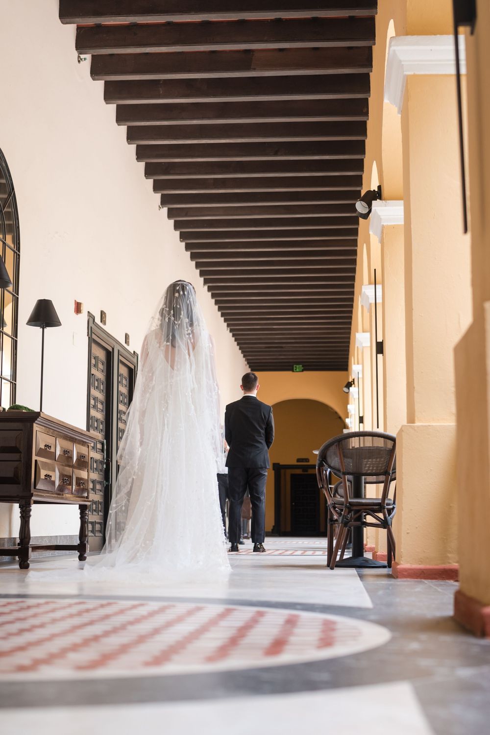 Groom walking through historic hallway at Hotel El Convento in Old San Juan Puerto Rico