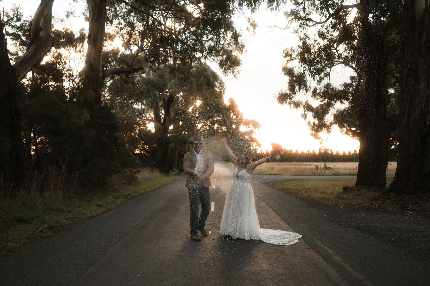 Silhouetted couple walking on a tree-lined path during golden sunset hour creating a romantic atmosphere.