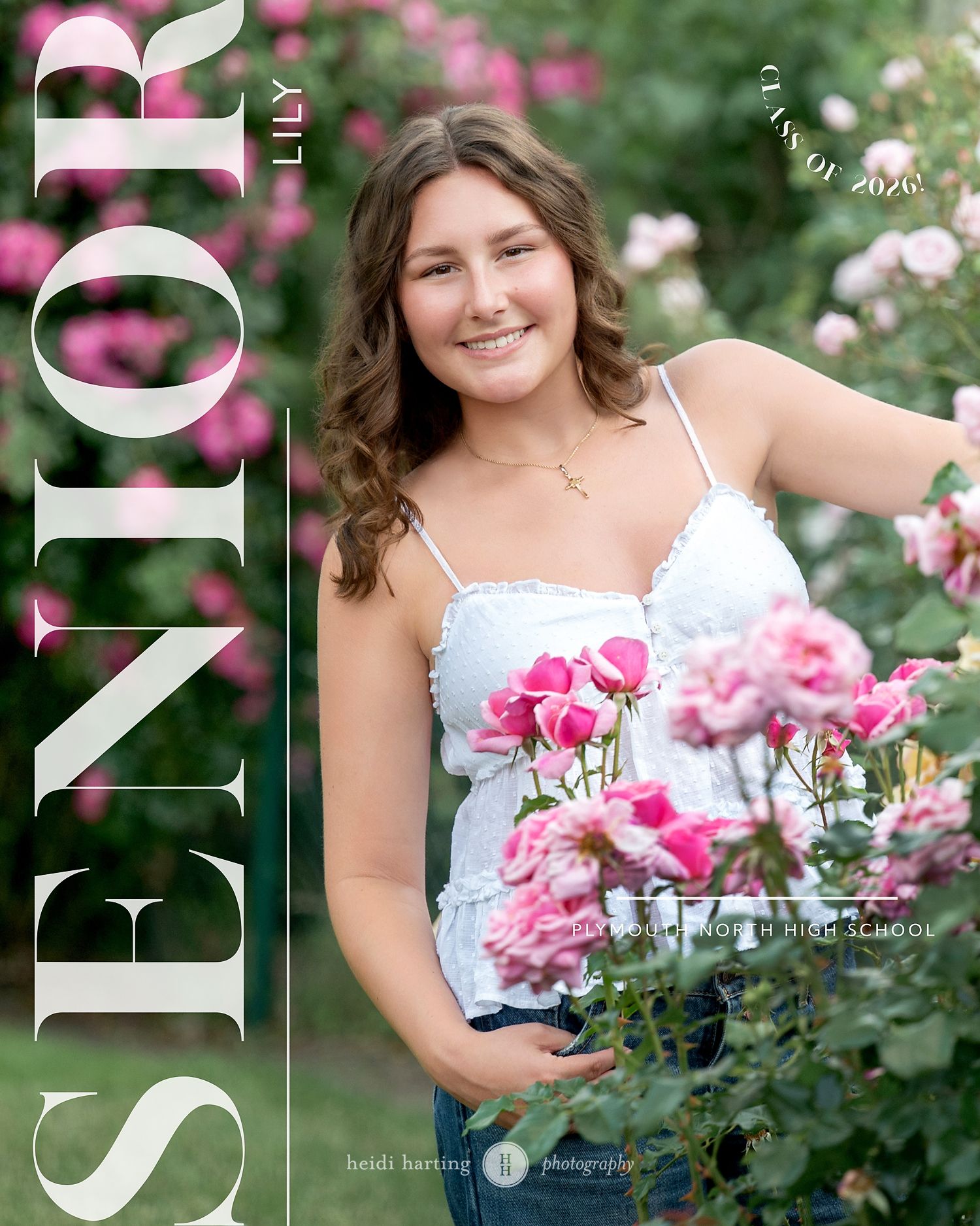 A senior portrait in a garden with blooming pink roses and soft bokeh background lighting effects.