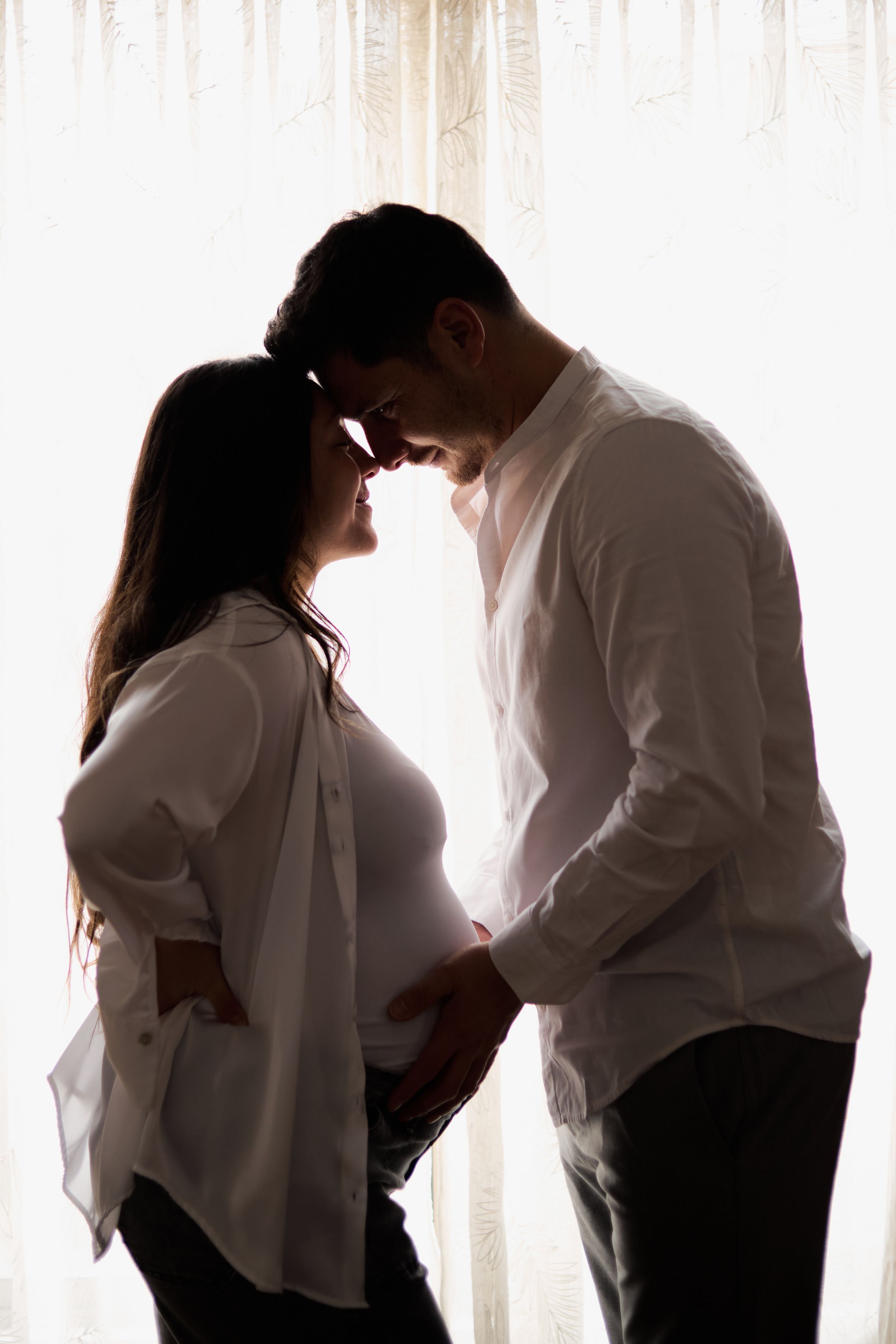 A sequence of silhouetted figures in white shirts against a bright window showing intimate romantic moments.