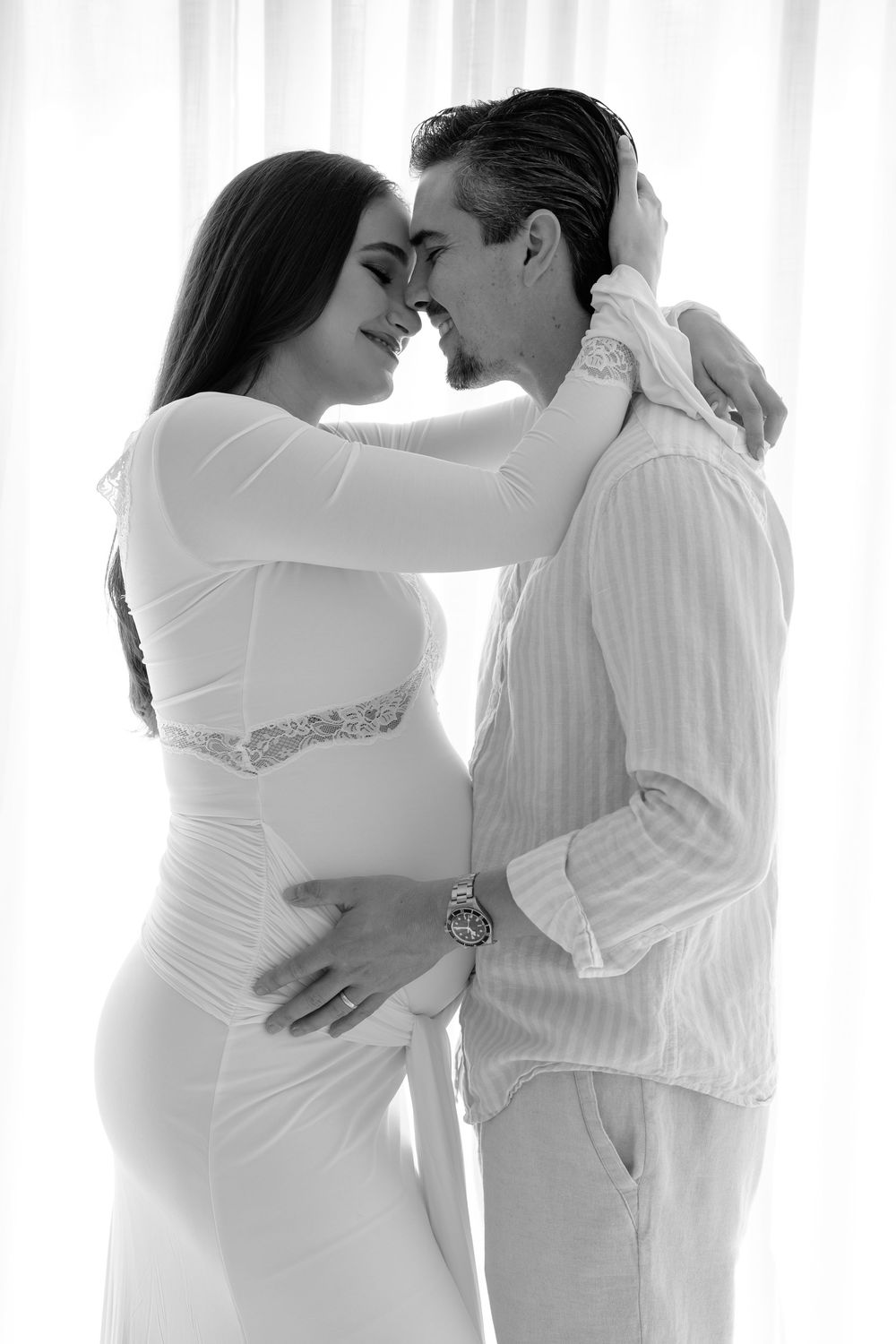 Three romantic couples in white clothing embrace and kiss in a minimalist black and white photo series.
