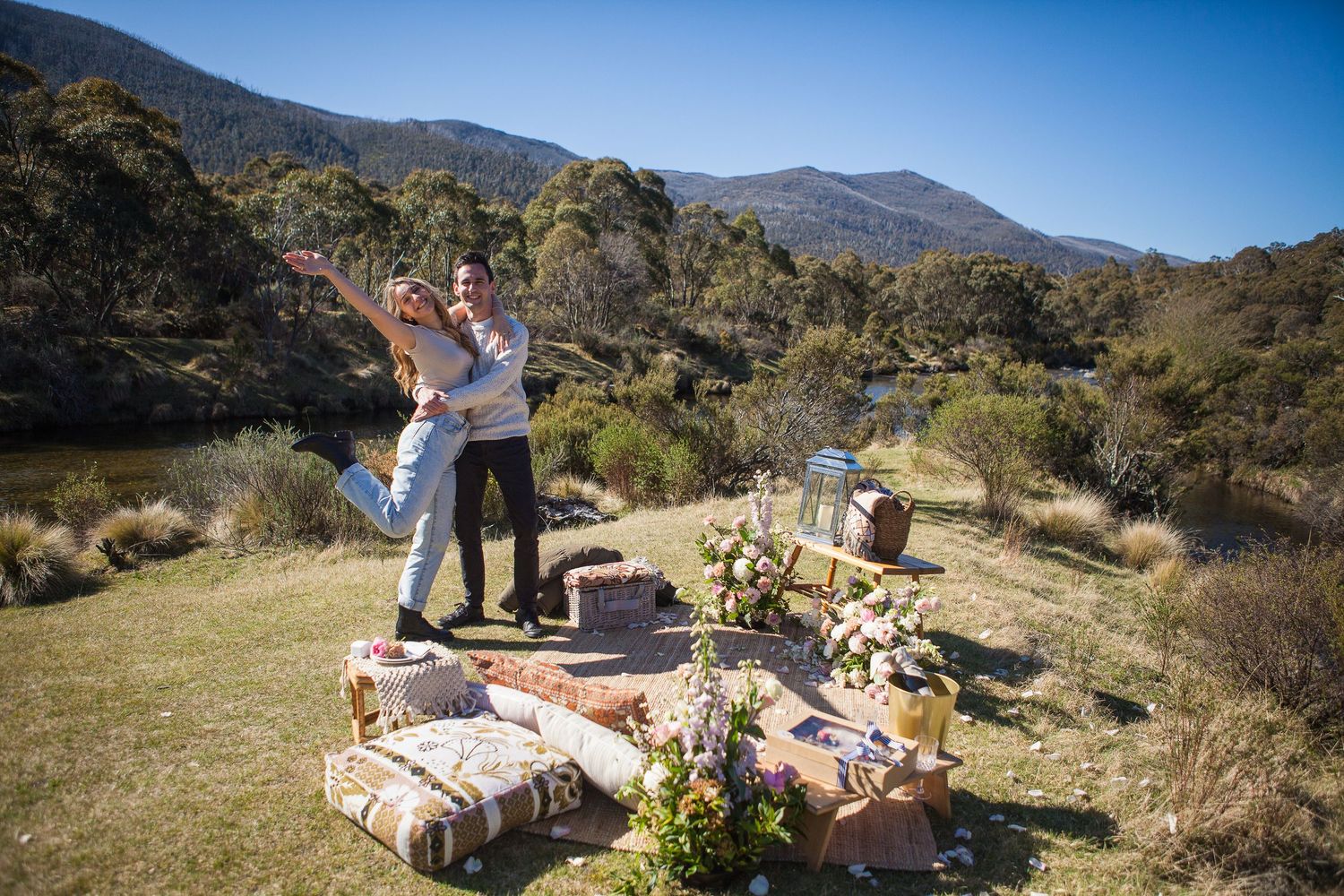 Scenic mountain picnic setup with blankets and food baskets laid out on a sunny day with desert landscape views.