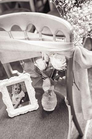 Decorative white photo frames and floral arrangements displayed at a wedding reception.