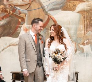 A romantic winter wedding scene with the couple embracing in front of a snowy backdrop and elegant decor.