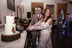 Wedding reception candid moments showing cake cutting and dancing in a decorated indoor venue.