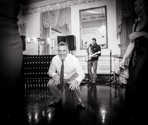 Black and white photos capture dynamic dance floor moments at an indoor wedding reception.