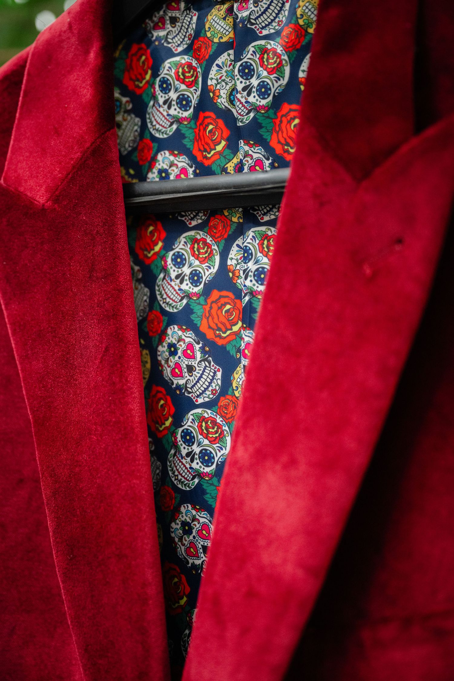 Close-up detail of a navy blue suit jacket with purple lining and orange piping showing craftsmanship details.
