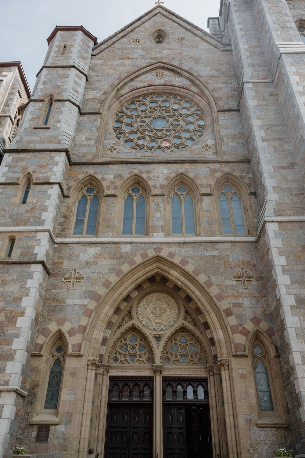 Gothic church facade with ornate rose window, pointed arch doorway, and stone architectural details in traditional style.