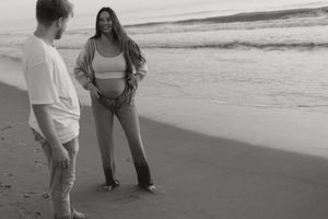 People walking and playing together along a scenic beach shoreline at sunset.