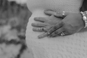 Black and white close-up image of hands displaying engagement rings in sequence.