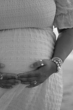 A series of black and white photos showing a hand with rings gently resting against textured fabric.