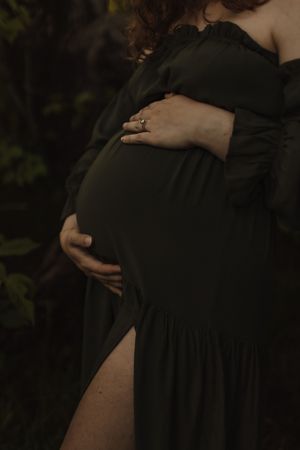 A series of maternity photos showing a pregnant woman in a dark green dress against a moody outdoor background.