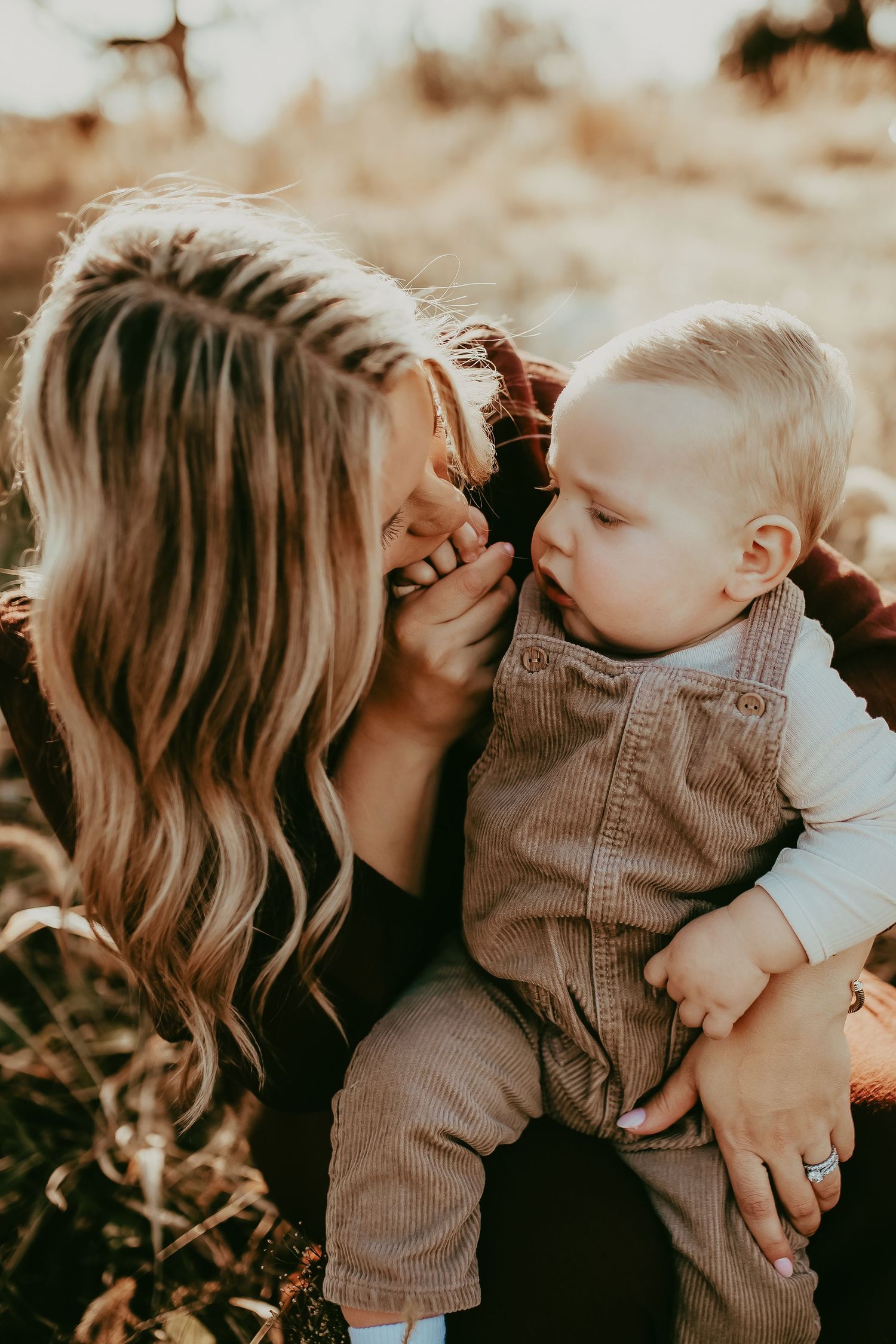 A tender moment between parent and child playing together outdoors in warm sunset lighting.