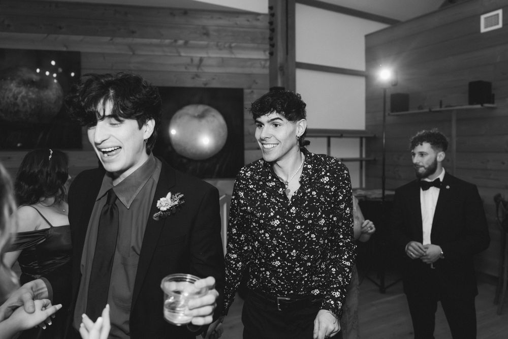 Candid black and white shots of wedding guests enjoying themselves at an evening reception.
