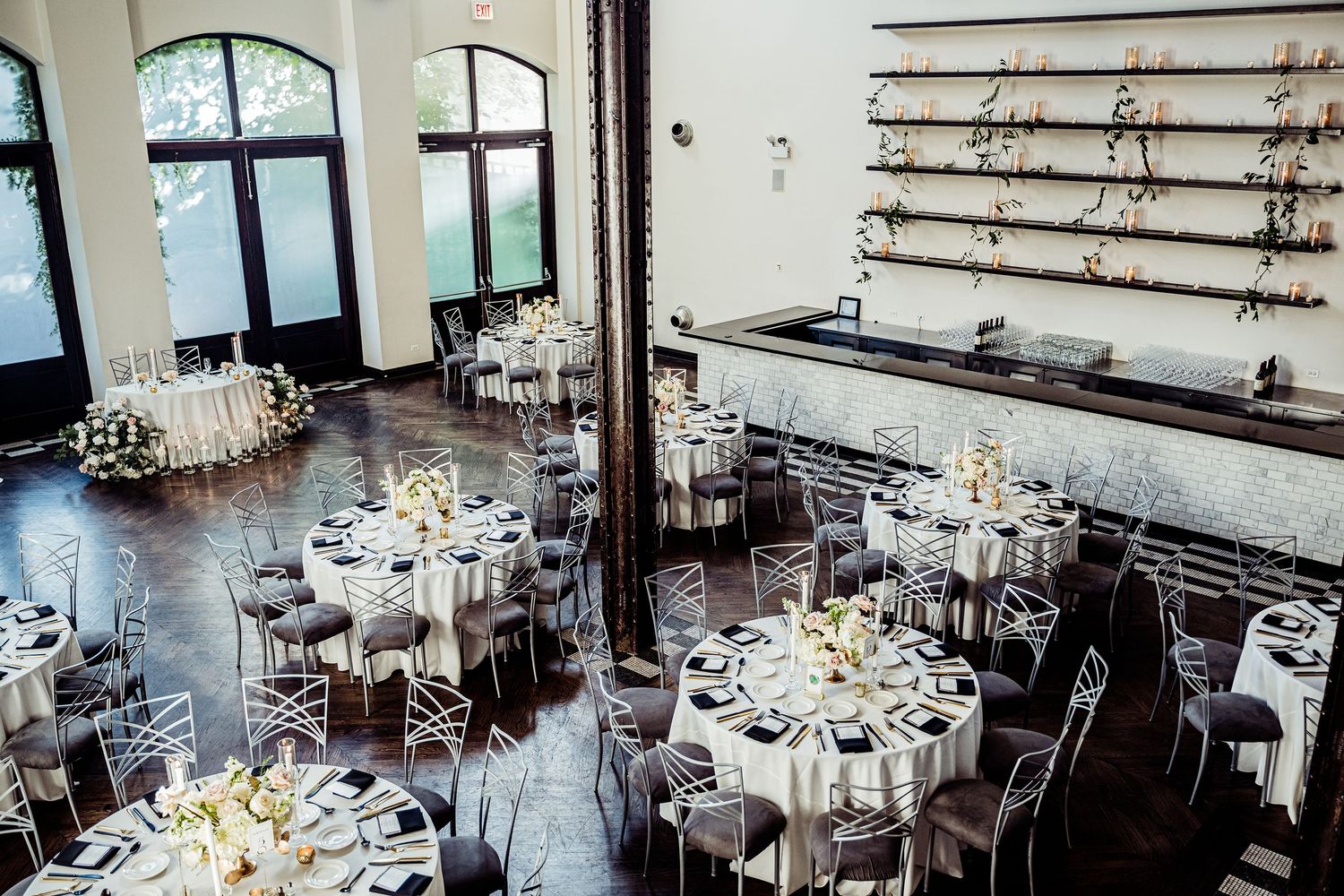 Elegant wedding reception venue with white-clothed tables and chairs arranged in a spacious banquet hall.