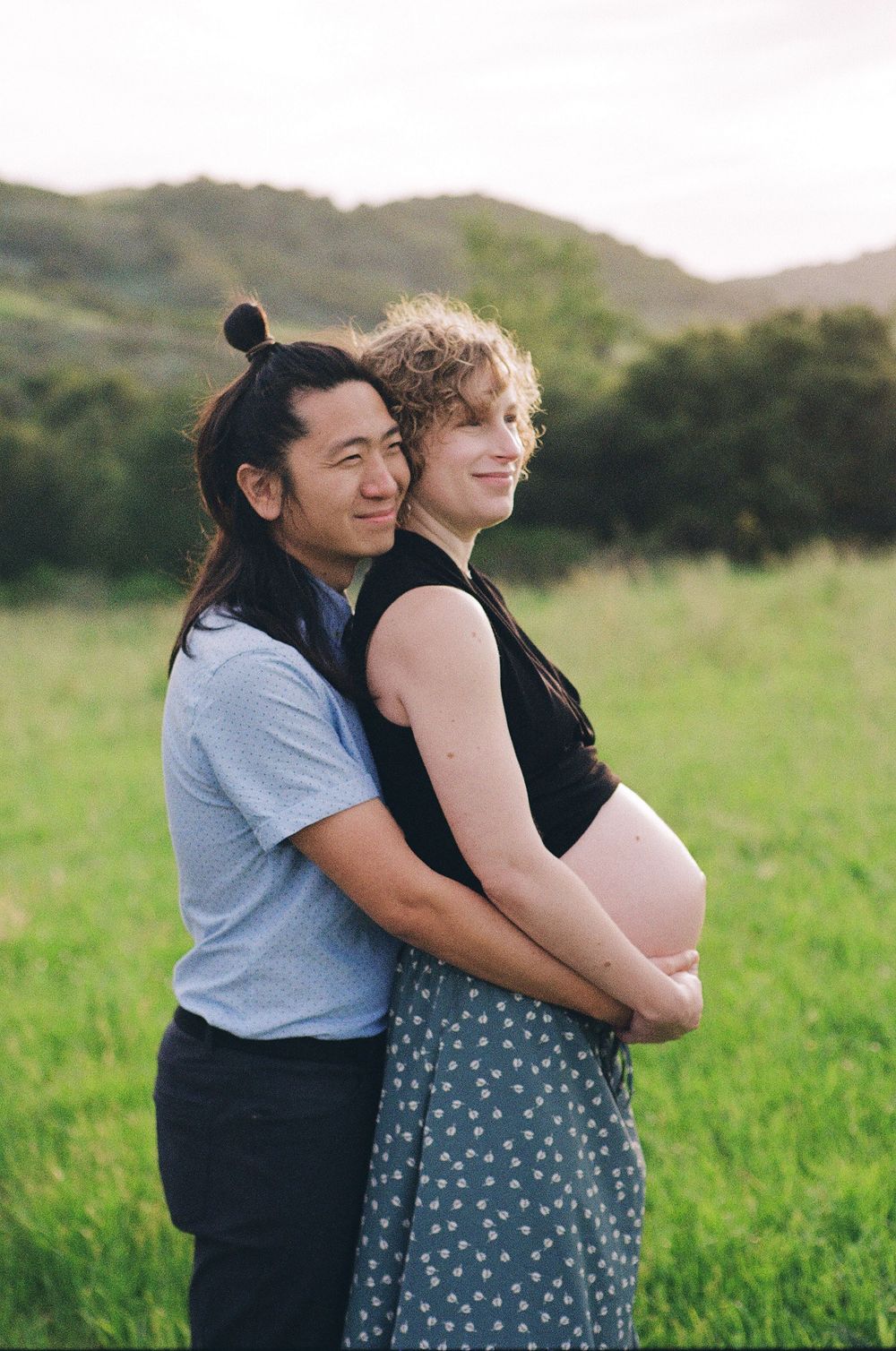A couple share a tender maternity photography moment on film photography showing film photography qualities