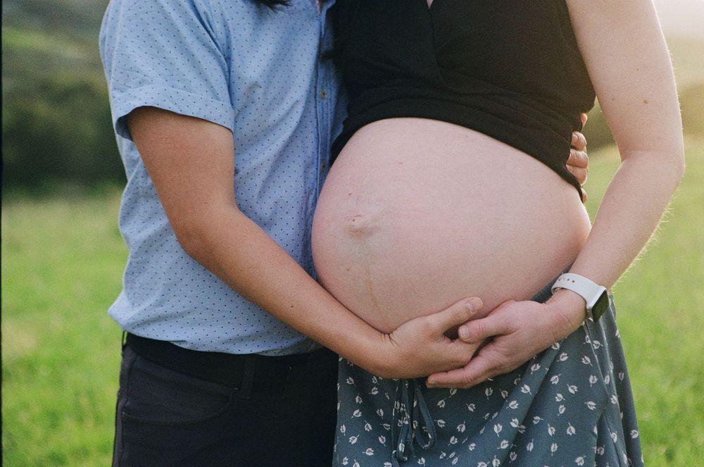 A belly photo from a golden hour film maternity session showing grain and timeless film textures