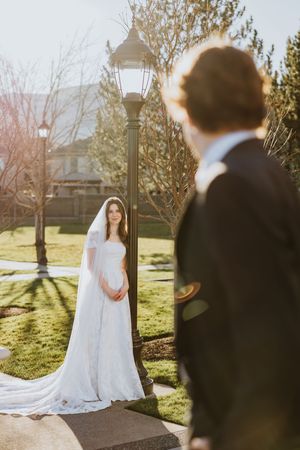 An over the shoulder shot of a man looking over at his wife in bridal attire