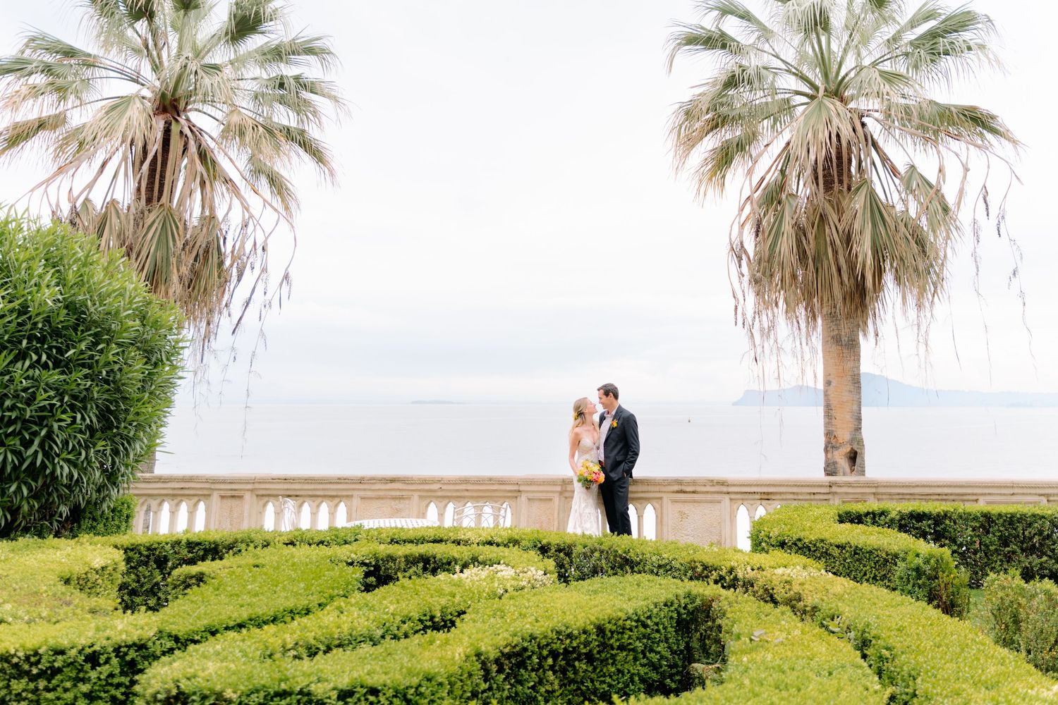 Bride and groom posing in the Italian gardens of Isola del Garda