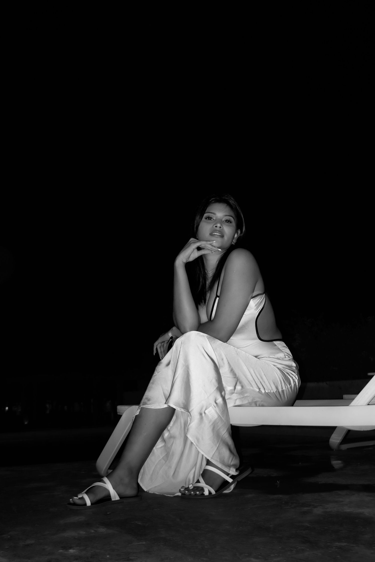 Artistic black and white photo series showing a figure in white clothing reclining against dark background.