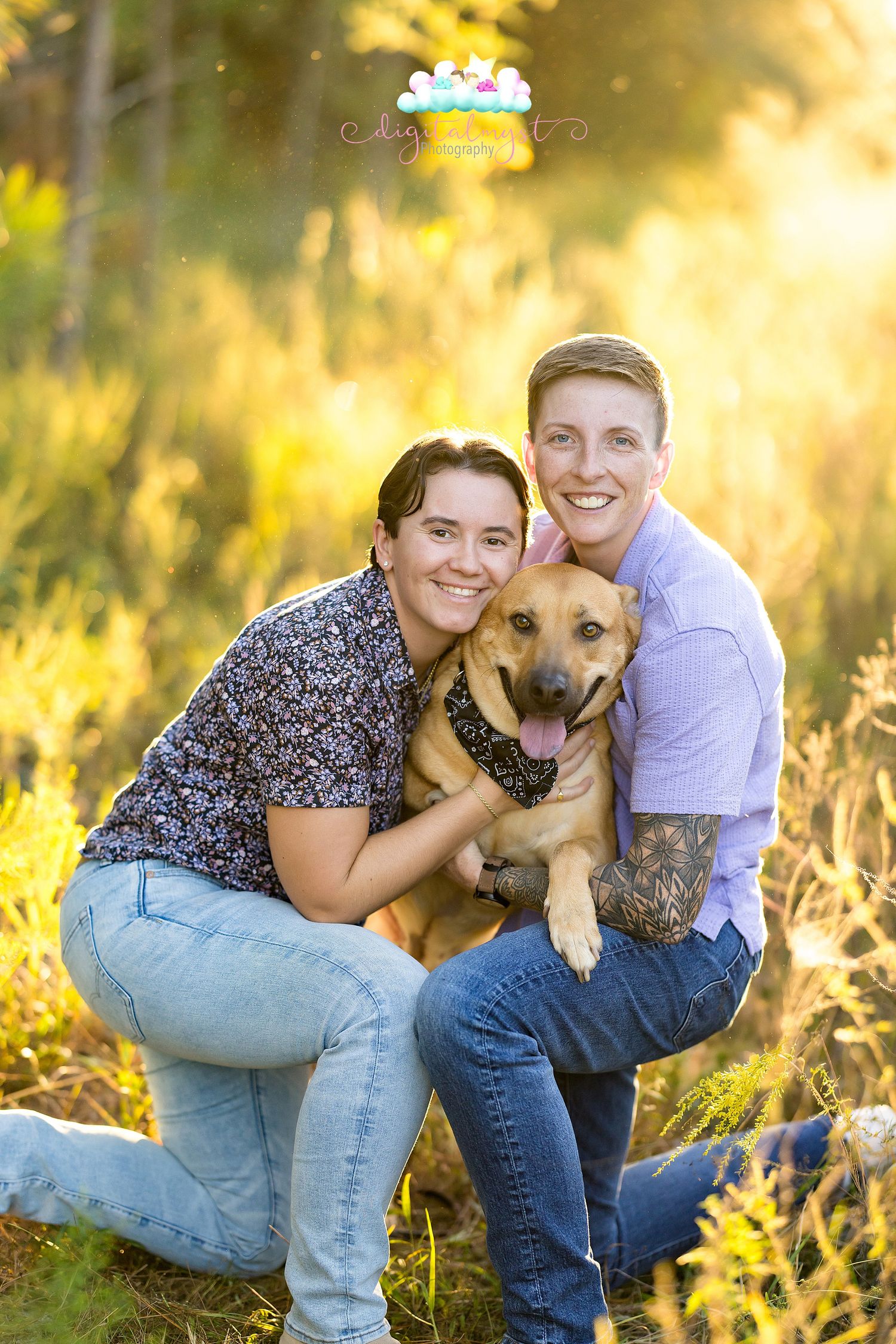 A couple poses with their German Shepherd mix dog in a sunlit field during golden hour.