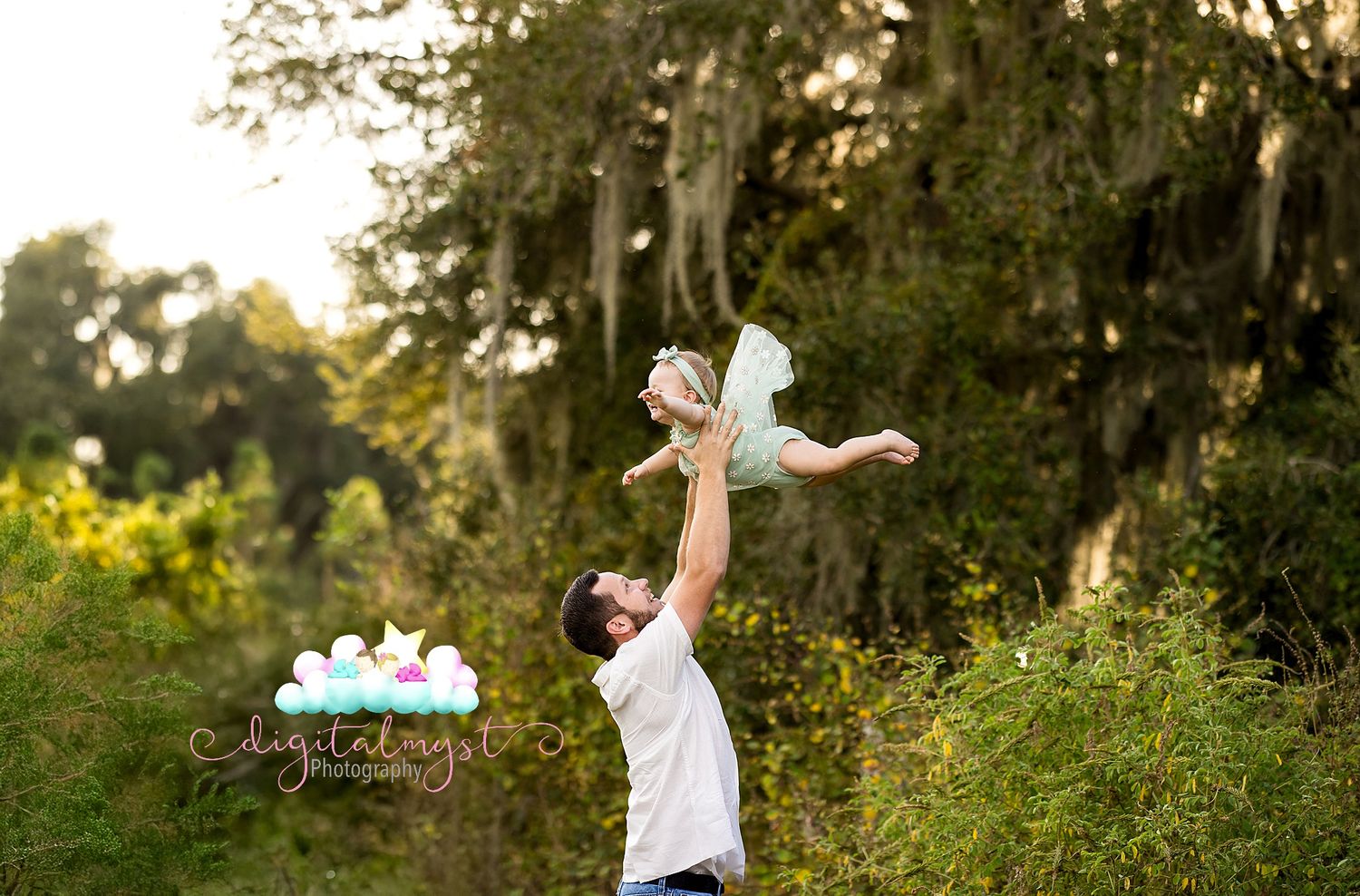 Children playing and running through a wildflower meadow at sunset with Spanish moss hanging from trees in background.