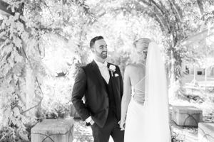 Black and white candid moments between the newlyweds in an outdoor garden setting.