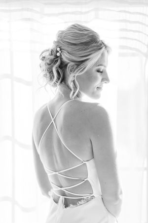 Elegant black and white photo showing intricate criss-cross back detail of a formal dress.