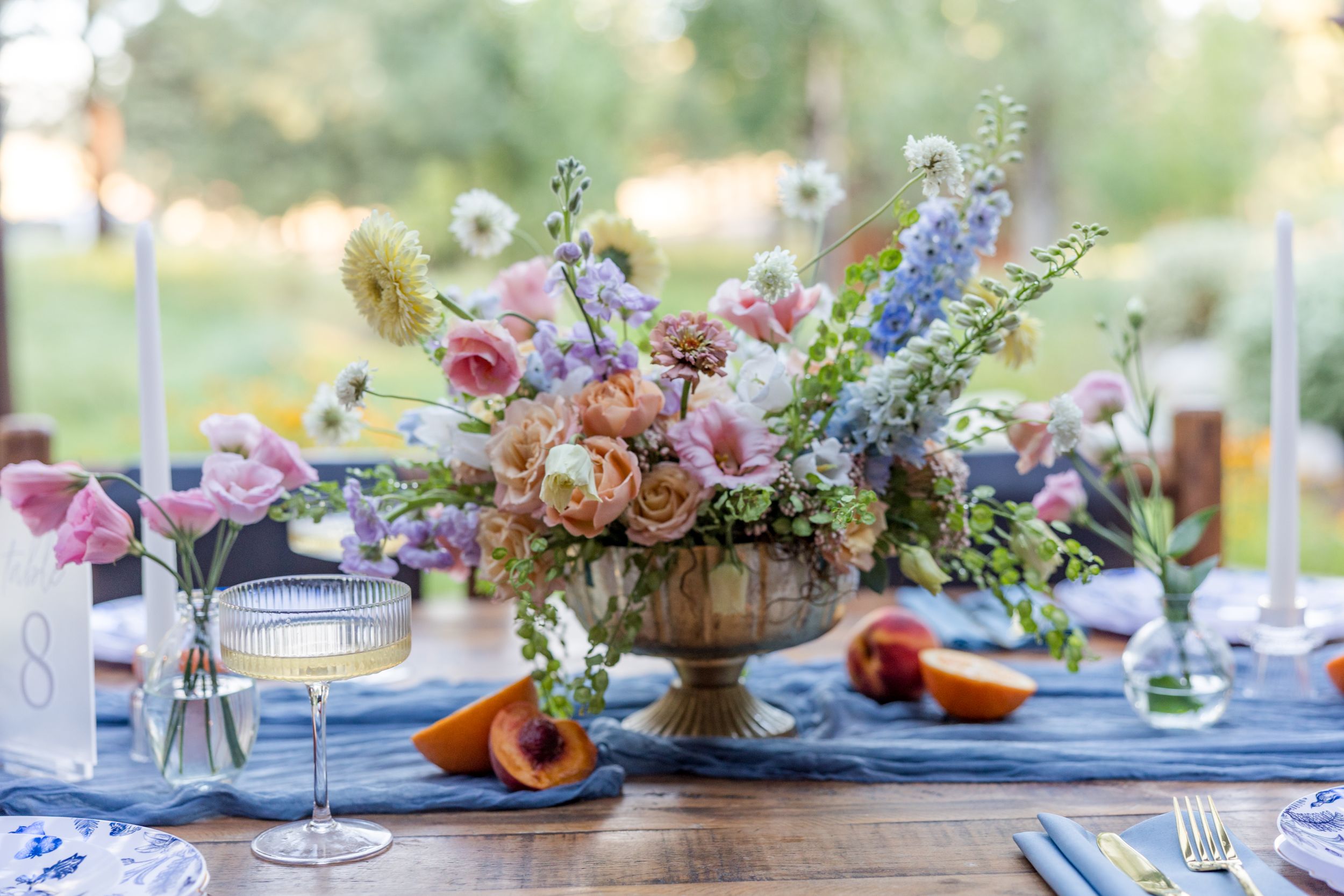 Romantic wedding table setting with colorful floral centerpieces and fine dinnerware.