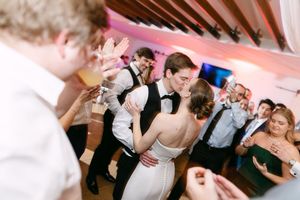 Bride and groom share a romantic first dance surrounded by guests at an elegant wedding reception.