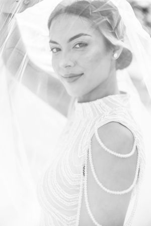 Black and white bridal portrait showcasing delicate pearl shoulder details and veil.