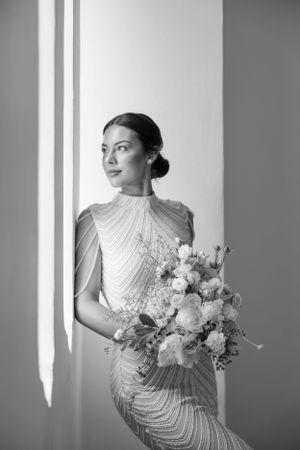 Artistic black and white bridal portraits highlighting a beaded gown and floral bouquet.