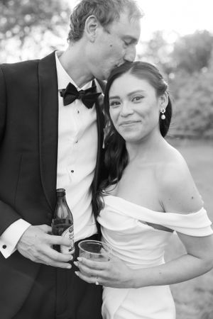 Black and white wedding portrait of couple sharing intimate moment with drinks.