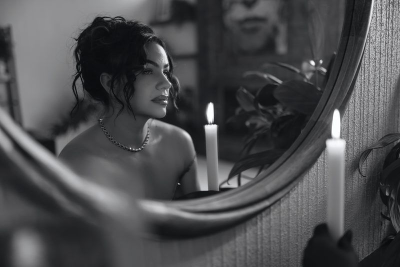Candlelit reflection in vintage mirror creating moody atmosphere.
