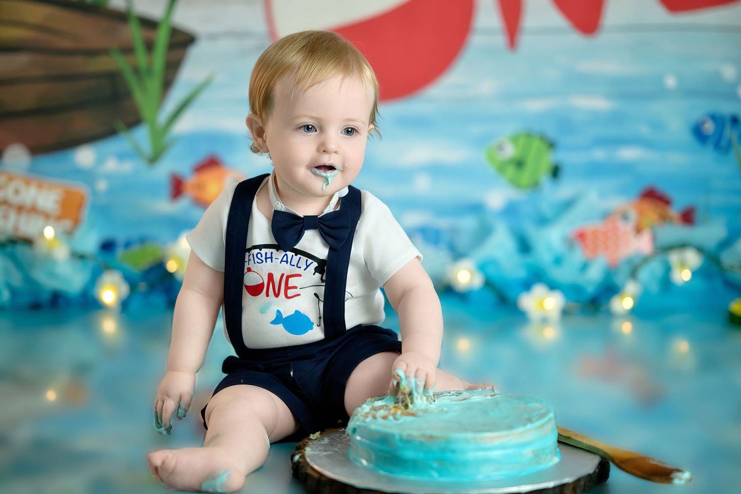 A first birthday cake smash photo series shows a baby in overalls playing with blue frosting and decorations.