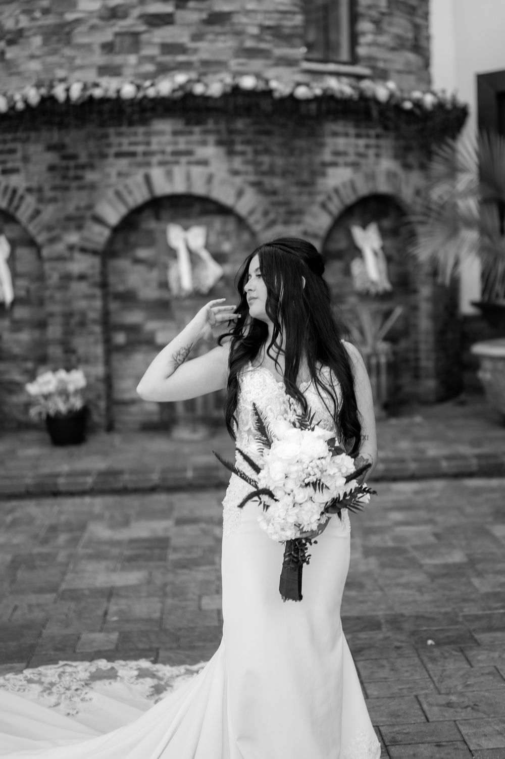 Black and white wedding photos showing romantic moments between couple on brick patio with flowing white dress.