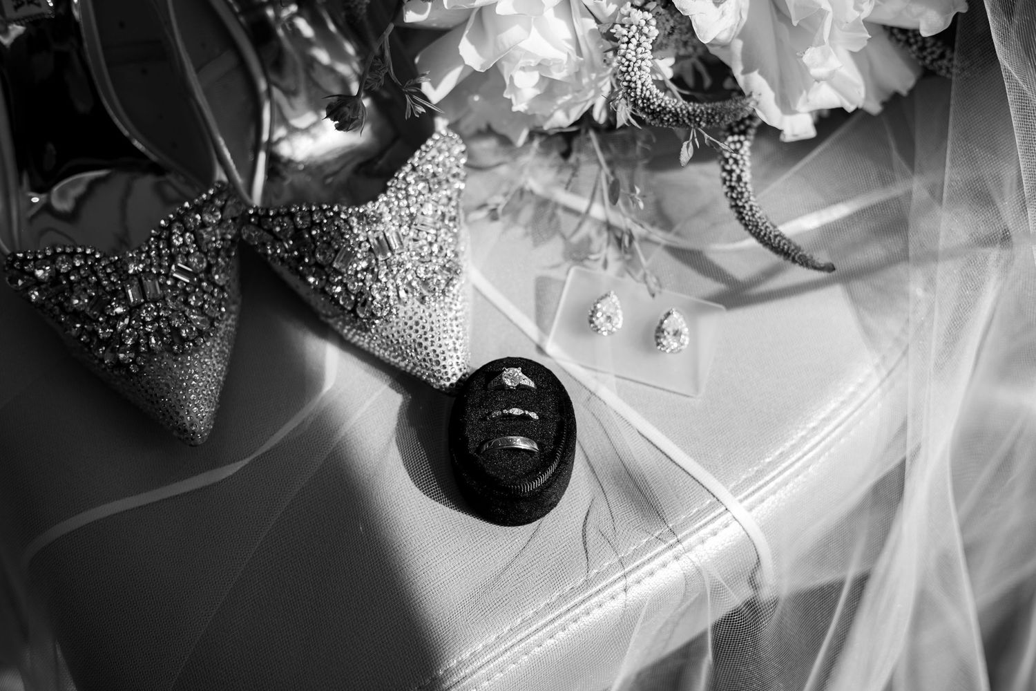 A black and white photo of a bride and groom dancing together during their first dance at a wedding reception.