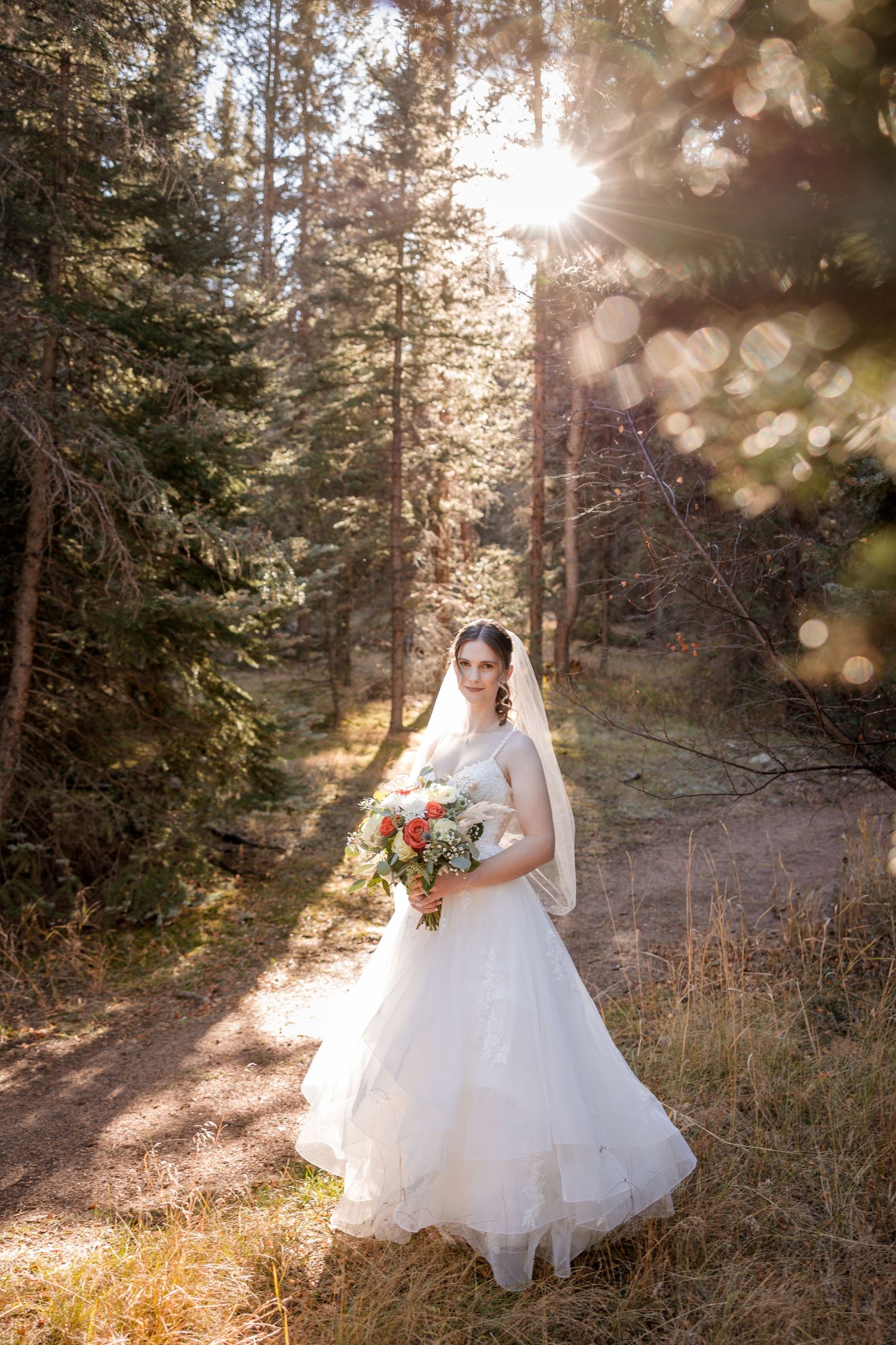 Ethereal sunlit forest scene with flowing white dress twirling among evergreen trees and golden light bokeh effects.