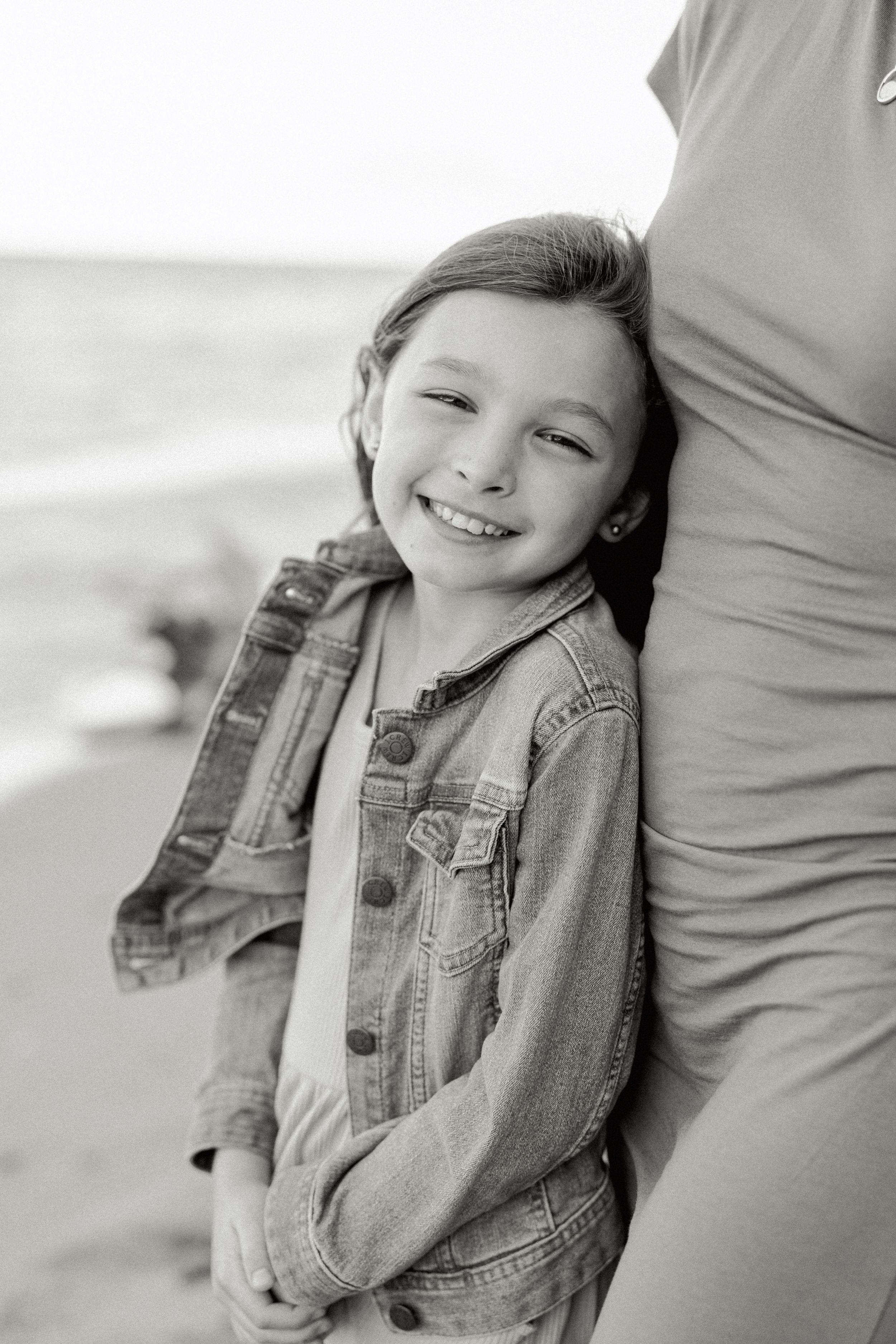 Black and white portrait of joyful expressions on a breezy beach day.