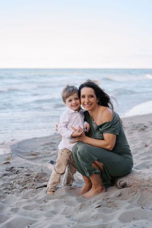 A touching moment captured between parent and child on a scenic beach at sunset.