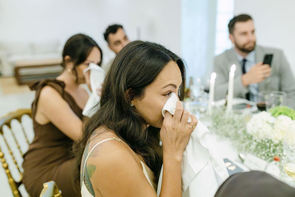 Emotional guest wiping tears during wedding speech at dinner reception in Lisbon Portugal