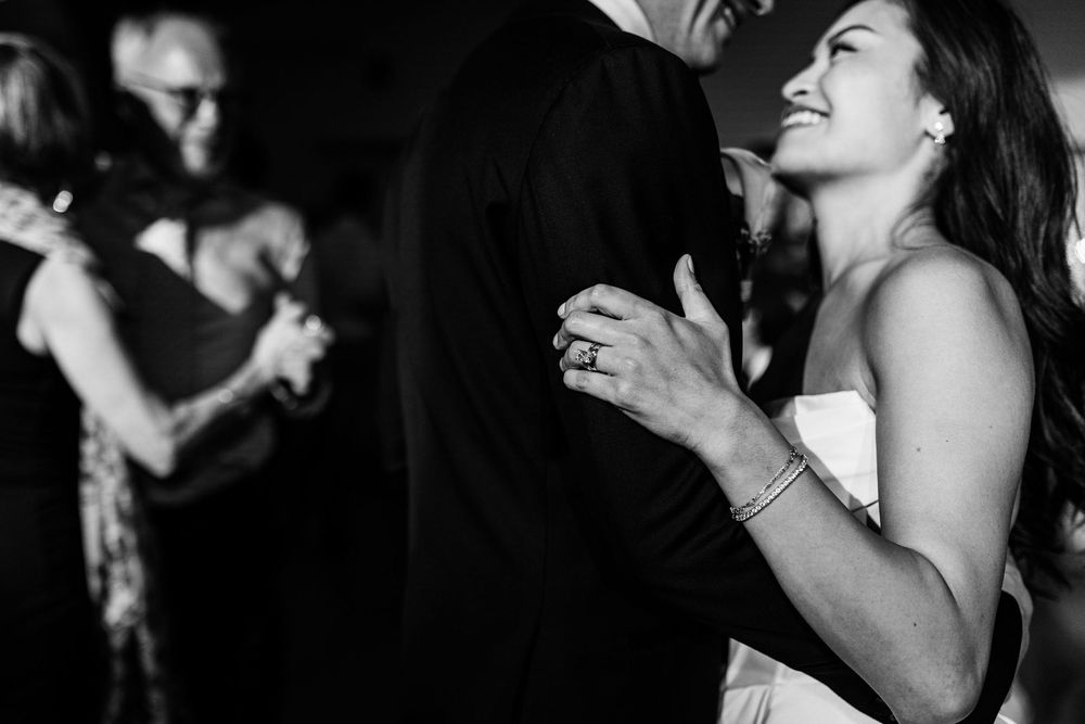 Bride smiling during first dance in black and white surrounded by guests at wedding reception in Lisbon