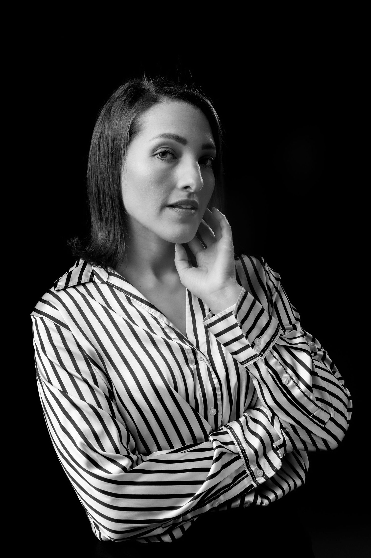 A dramatic black and white portrait series showing a figure in a striped shirt against a dark background.