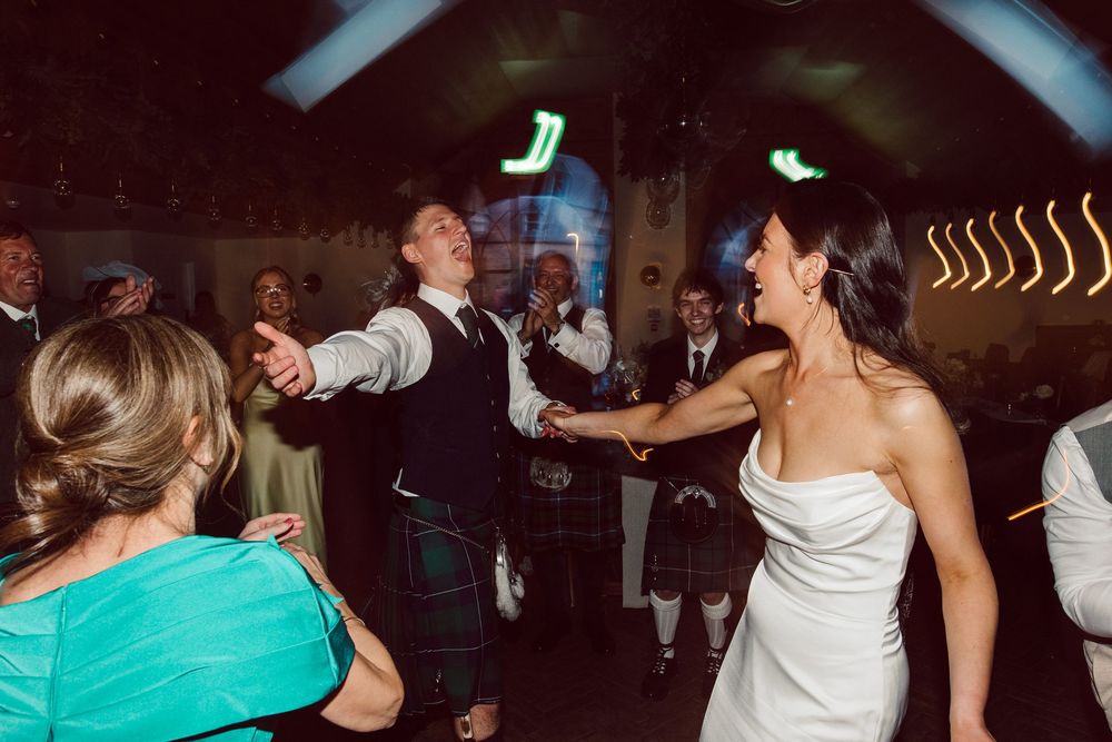 People dancing and celebrating at a lively nightclub party with colorful lights and energetic atmosphere.