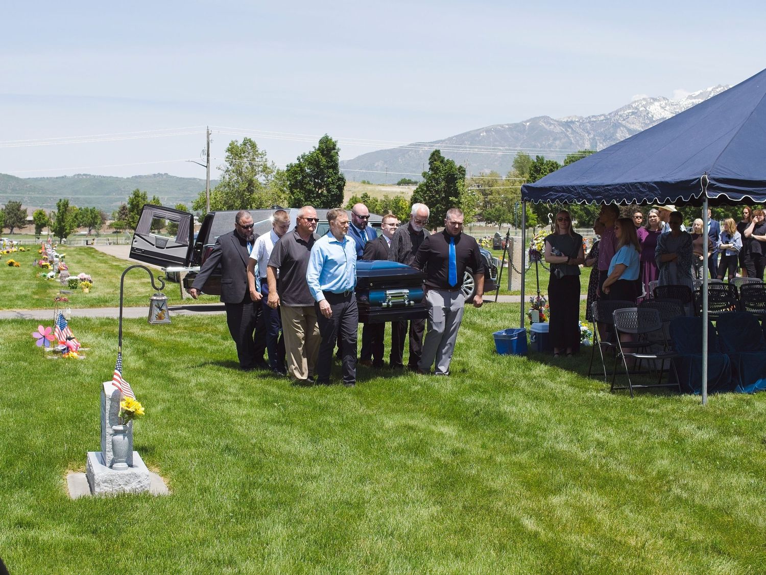 Pallbearers carry a casket to the burial site